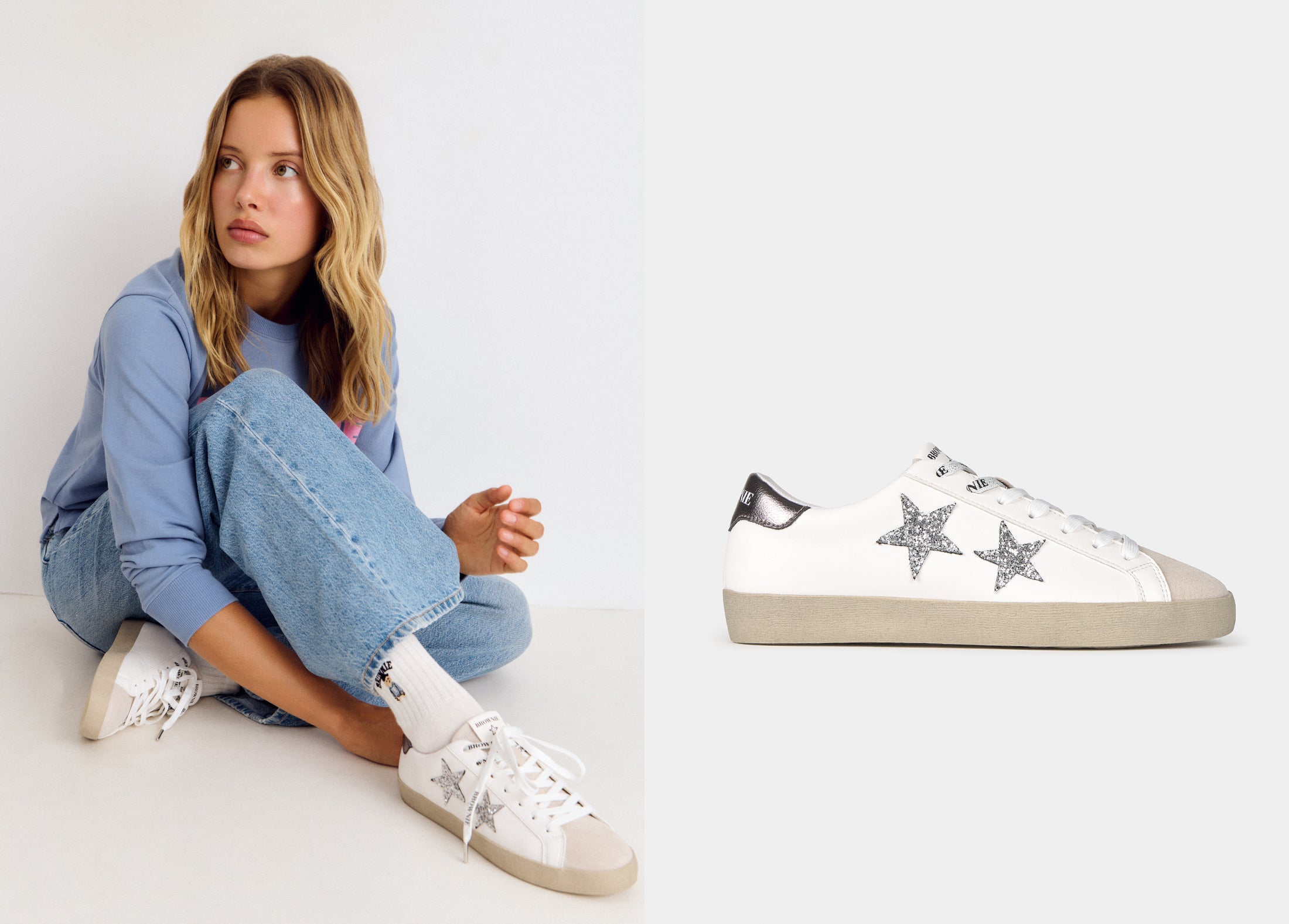 Zapatillas deportivas blancas con estrellas plateadas en el lateral, luciendo su suela de goma beige sobre modelo.
