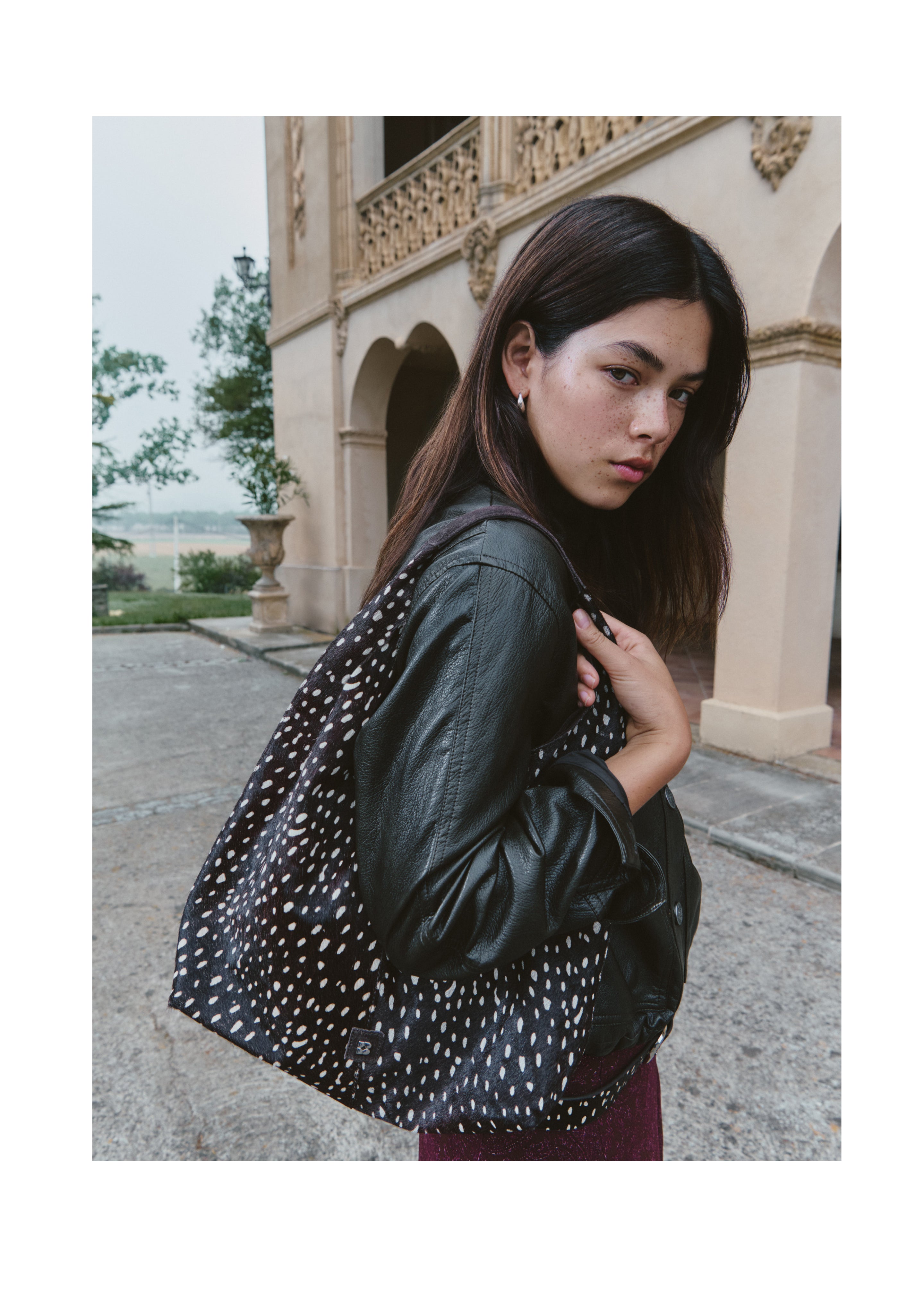 Bolso de hombro marrón con estampado animal print lucido sobre el hombro
